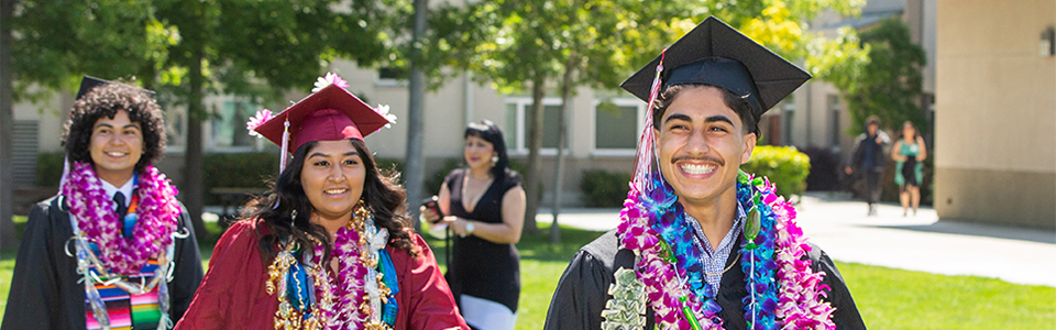 Three soon-to-be graduates walk outside